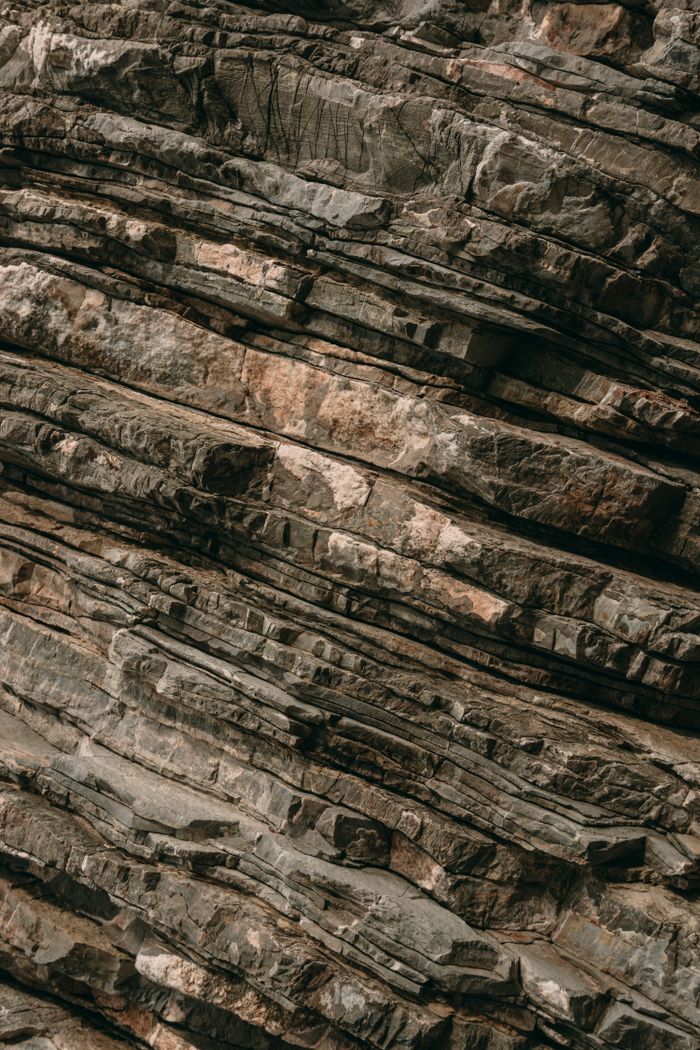 Close-up of a textured, layered rock formation in Budva, Montenegro, showcasing geological beauty.